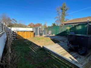 a backyard with a wooden deck and a fence at La Casa Montussan in Montussan