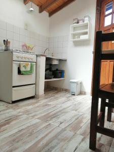 a kitchen with a white stove and a wooden floor at Las Adelas Chaltén in El Chalten