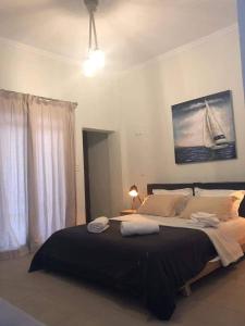 a bedroom with a large bed with a black blanket at Utopia suites in Egina