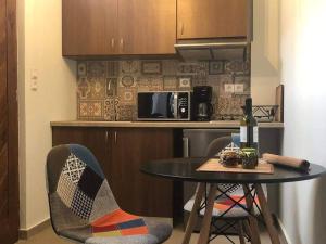 a kitchen with a table and two chairs and a microwave at Utopia suites in Egina