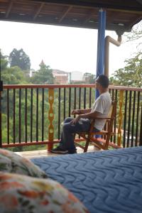 a man sitting on a swing on a porch at Jaibaná Spa in Támesis