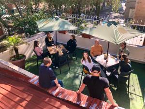 a group of people sitting at tables under umbrellas at El Patio Hostel Quito in Quito +46 photos