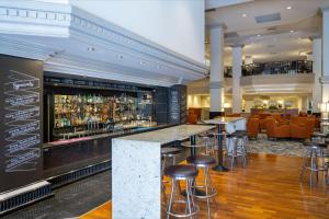 a bar in the lobby of a hotel with stools at Hotel Grand Chancellor Adelaide in Adelaide