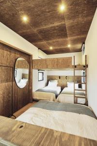 a bedroom with two beds and a mirror at GLANSTELLA CABIN Fujiyamanakako in Yamanakako