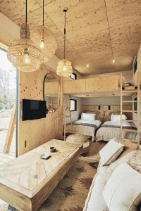 山中湖村にあるGLANSTELLA CABIN Fujiyamanakakoのリビングルーム(ベッド2台、テーブル付)