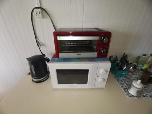 a red microwave sitting on top of a counter at Hostal y Cabañas Maribel Zuñiga in Valdivia