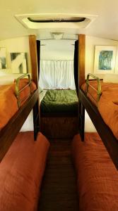 two beds in the middle of a room at Mesa Bus - Deluxe Byron Hinterland Eco Stay in Rosebank