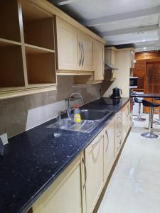 a kitchen with a sink and a black counter top at Relevant properties in Welling