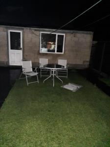 a patio with a table and chairs at night at Relevant properties in Welling
