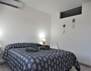 a bedroom with a bed with a black and white blanket at Alem Mendoza in Mendoza