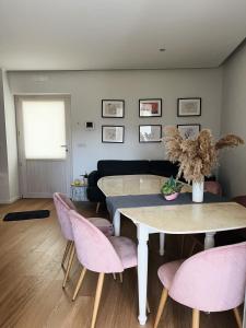 ein Esszimmer mit einem Tisch und rosa Stühlen in der Unterkunft Il Cortile in Enna