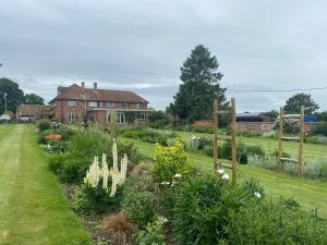 a garden with flowers in front of a house at Chadwell Hill Farm in Longwick