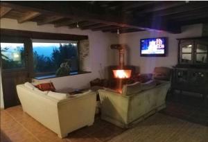 sala de estar con 2 sofás y TV en Casa de piedra en pequeña aldea de Ortigueira 