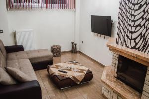 a living room with a couch and a fireplace at g.home in Tríkala