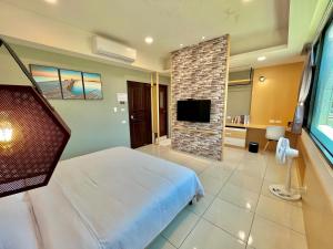 um quarto com uma cama, uma televisão e uma lareira em 14 Art Villa em Tainan