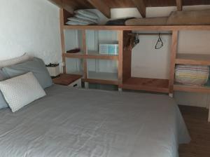 a bedroom with a bed and shelves in a room at Casa Vapahí in Barra de Valizas