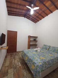 a bedroom with a bed and a ceiling fan at Casa Bete e Farouk in São Miguel do Gostoso