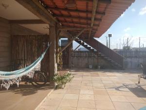 a patio with a hammock and a staircase at Casa Bete e Farouk in São Miguel do Gostoso