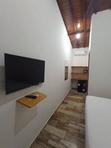 a living room with a flat screen tv on a wall at Casa Bete e Farouk in São Miguel do Gostoso