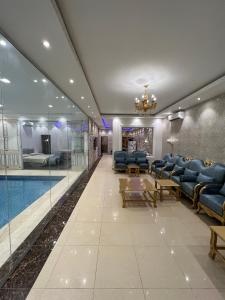 a hotel lobby with a swimming pool and blue chairs at شاليه فاملي دي family day in Hail