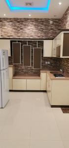 a kitchen with white counters and a white refrigerator at شاليه فاملي دي family day in Hail