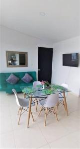 une salle à manger avec une table et des chaises en verre dans l'établissement Apartasol Amor y Café, Reserva de la Colina, à La Tebaida