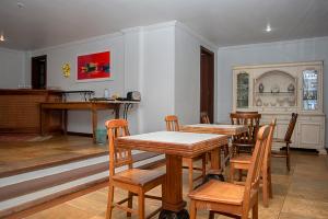 a dining room with wooden tables and chairs at Villa Bella Ferradura in Búzios