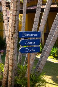 um sinal de rua em frente a algumas palmeiras em Villa Bella Ferradura em Búzios
