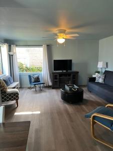 a living room with a blue couch and a tv at Guesthouse Cannon Beach in Cannon Beach