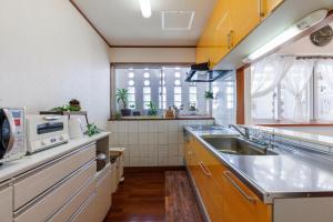 a kitchen with a sink and a microwave at Laulea YAKA in Kin