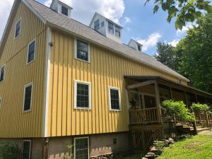 a yellow house with a gambrel roof at Yellow Barn Estate in Freeville +60 photos