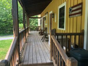 a porch of a yellow house with a wooden deck at Yellow Barn Estate in Freeville