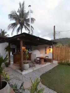 バーハ・ド・サイにあるHakuna Studios Barra do Sahyの椰子の木とテーブルのある家