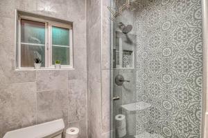 a bathroom with a shower with a toilet and a window at Close to Everything Cozy Duplex B in Downtown, UTEP, Hospitals in El Paso