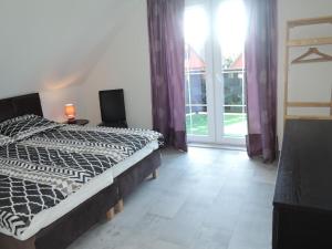 sypialnia z łóżkiem i dużym oknem w obiekcie Modern holiday homes for 8 people with the pool w mieście Kołczewo +29 zdjęć