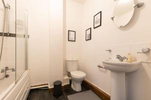 y baño con aseo, lavabo y espejo. en Emerald - 2 bedroom flat - sleeps 5 with parking., en Southampton