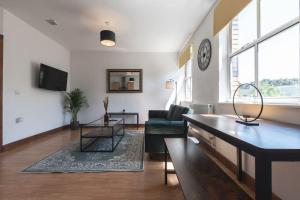 sala de estar con sofá y mesa en Emerald - 2 bedroom flat - sleeps 5 with parking., en Southampton
