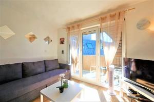 sala de estar con sofá y ventana grande en EMbnb - Studio Near Geneva - S204,4 en Étrembières