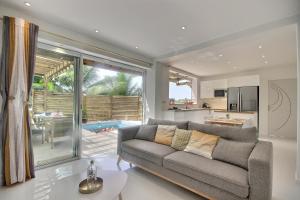 a living room with a couch and a kitchen at Villa Linay in Le Diamant