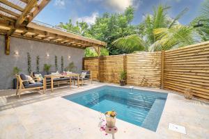 a backyard with a swimming pool and a wooden fence at Villa Linay in Le Diamant