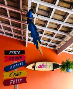 a bunch of signs hanging from a ceiling with surfboards at Pousada da Sú in Bertioga