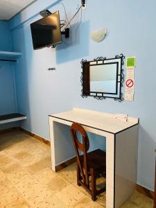a desk with a mirror and a chair in a room at Casa Palma Hotel in Playa del Carmen