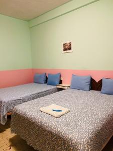 two beds in a room with blue and green walls at Casa Palma Hotel in Playa del Carmen