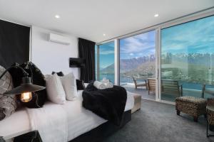 a bedroom with a bed with a view of the mountains at Remarkable Lake House in Queenstown