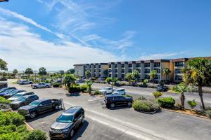 a parking lot with cars parked in front of a hotel at HH Beach & Tennis 240C in Hilton Head Island