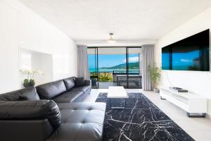 Airlie Beach的住宿－Ocean Views at Whitsunday Terraces Resort，客厅配有沙发和桌子