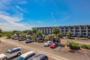 a parking lot with cars parked in front of a building at HH Beach & Tennis 245B in Hilton Head Island