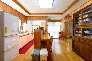 uma cozinha com uma mesa e um frigorífico em すなだの家 em Uwajima