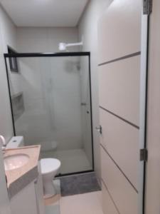 een badkamer met een douche, een toilet en een wastafel bij FLATS TAVARES ARAUJO 202 in Garanhuns