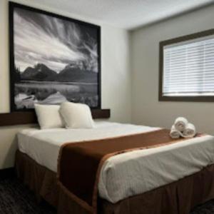 a bedroom with a large bed with a large picture on the wall at Super 8 by Wyndham Penticton in Penticton